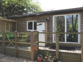 An outdoor area with a deck and furniture at Orchard Lodge in Bolney