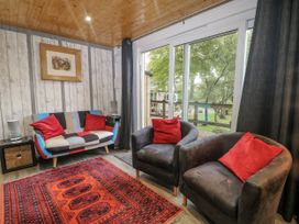 A living room with a sofa and armchairs at Harvest Lodge in Wineham near Bolney
