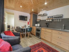 A kitchen with a stove, oven, and dining table at Harvest Lodge in Wineham near Bolney