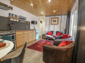 A kitchen area with seating and appliances at Harvest Lodge in Wineham near Bolney