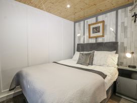 A bedroom with a bed and bedside table at Harvest Lodge in Wineham near Bolney