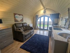 A living room with a sofa and TV at Stapeley Pod White Grit near Chirbury