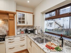 A kitchen with granite countertops and sink at Beachcrest in Whitby