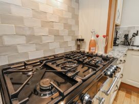 A kitchen with a stove, a bottle and glasses at Beachcrest, Whitby