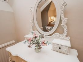 A table with a mirror and vase of flowers at Beachcrest in Whitby