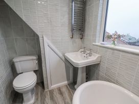 A bathroom with a bathtub, toilet, and sink at Beachcrest in Whitby