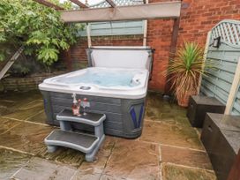 A hot tub with steps and a drink on a stool at Beachcrest in Whitby