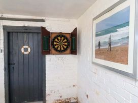 A snug with a dartboard and a door at Beachcrest in Whitby