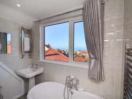 A bathroom with a bathtub, sink, and window view at Beachcrest in Whitby