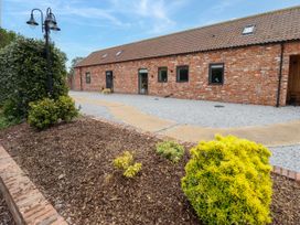 A brick building with a tiled roof and small shrubs in a garden near a gravel path at Pheasant's Roost in Lelley near Burton Pidsea