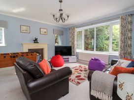 A living room with a television and a foosball table at Raincliffe Manor in Scarborough