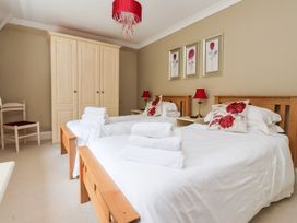 A bedroom with two beds and a wardrobe at Raincliffe Manor in Scarborough
