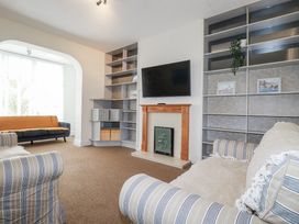 A living room with a sofa and television at The Three Tees in Newquay