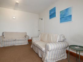 A living room with sofas and wall art at The Three Tees in Newquay