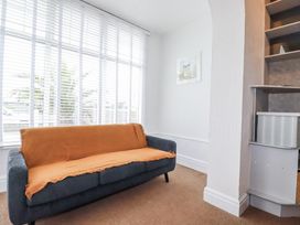 A living room with a sofa and window blinds at The Three Tees in Newquay