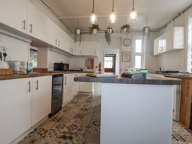 A kitchen with white cabinets and countertops at The Three Tees in Newquay