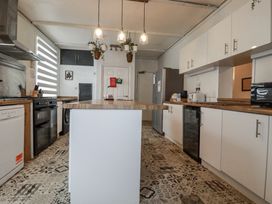 A kitchen with appliances and a kitchen island at The Three Tees in Newquay