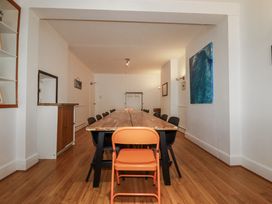 A dining room with a long table and chairs at The Three Tees in Newquay
