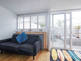 A snug with a couch and sliding door leading to outdoor area at The Three Tees in Newquay