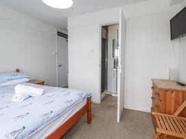 A bedroom with a bed and an adjoining bathroom at The Three Tees in Newquay