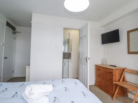 A bedroom with a bed and a connected bathroom at The Three Tees in Newquay
