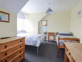 A bedroom with two beds and a mirror at The Three Tees in Newquay