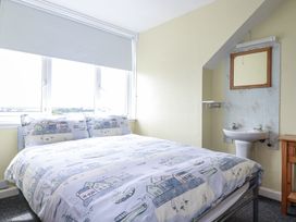 A bedroom with a bed and sink at The Three Tees in Newquay