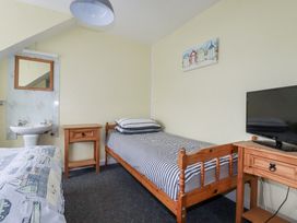 A bedroom with a bed, sink and mirror at The Three Tees in Newquay