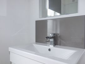 A bathroom with a sink and mirror at The Three Tees in Newquay