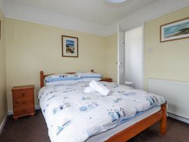 A bedroom with a bed and a nightstand at The Three Tees in Newquay
