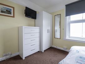 A bedroom with a bed, wardrobe, and television at The Three Tees in Newquay