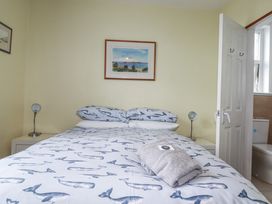 A bedroom with a bed and bedside table at The Three Tees in Newquay