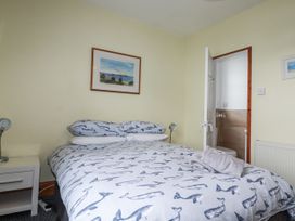 A bedroom with a bed and bedside table at The Three Tees in Newquay
