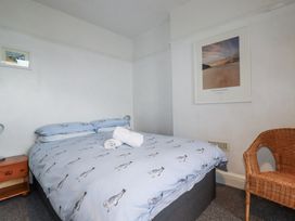 A bedroom with a bed and chair at The Three Tees in Newquay