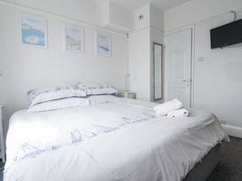 A bedroom with a bed and television at The Three Tees in Newquay