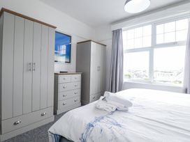 A bedroom with a bed and wardrobes at The Three Tees in Newquay