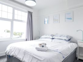 A bedroom with a bed and wall art at The Three Tees in Newquay