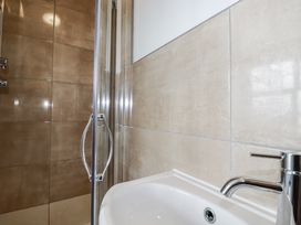 A bathroom with a shower and wash basin at The Three Tees in Newquay