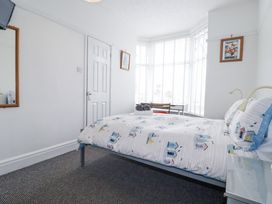 A bedroom with a bed and a nightstand at The Three Tees in Newquay