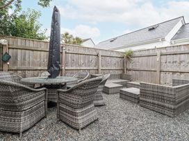 An outdoor seating area with a table and chairs at The Three Tees in Newquay