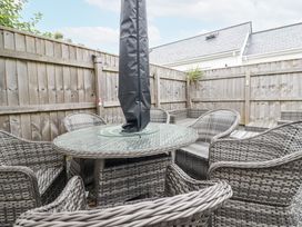 An outdoor seating area with a table and chairs at The Three Tees in Newquay