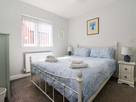 A bedroom with a bed and bedside tables with lamps at Southview Bungalow in Barmston