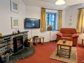 A living room with a fireplace and television at The Roundhouse, Warbstow