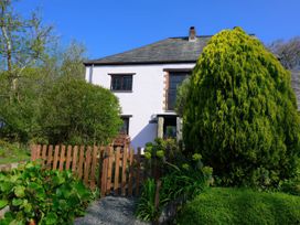 A house with a fence and trees at Little Leighs in Warbstow