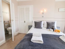 A bedroom with a bed with folded towels and breakfast tray next to a bathroom at North Beach Lodge in Scarborough