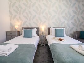 A bedroom with two single beds separated by a bedside table with lamps at North Beach Lodge in Scarborough