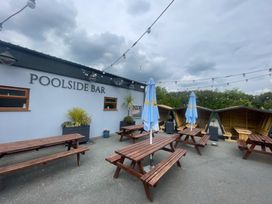An outdoor dining area with tables and umbrellas at Eirlys in Caeathro near Caernarfon