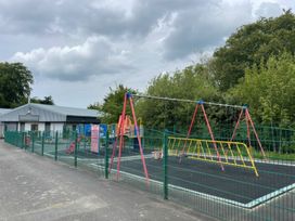A playground with swings and a play structure at a school