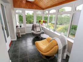 A conservatory with chairs and flowers at Churchfield House, Moygownagh near Crossmolina, County Mayo