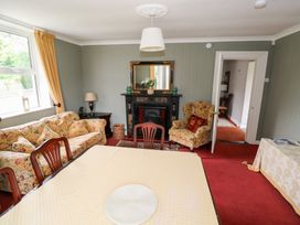 A living room with a sofa, table, and fireplace at Churchfield House in Moygownagh near Crossmolina, County Mayo